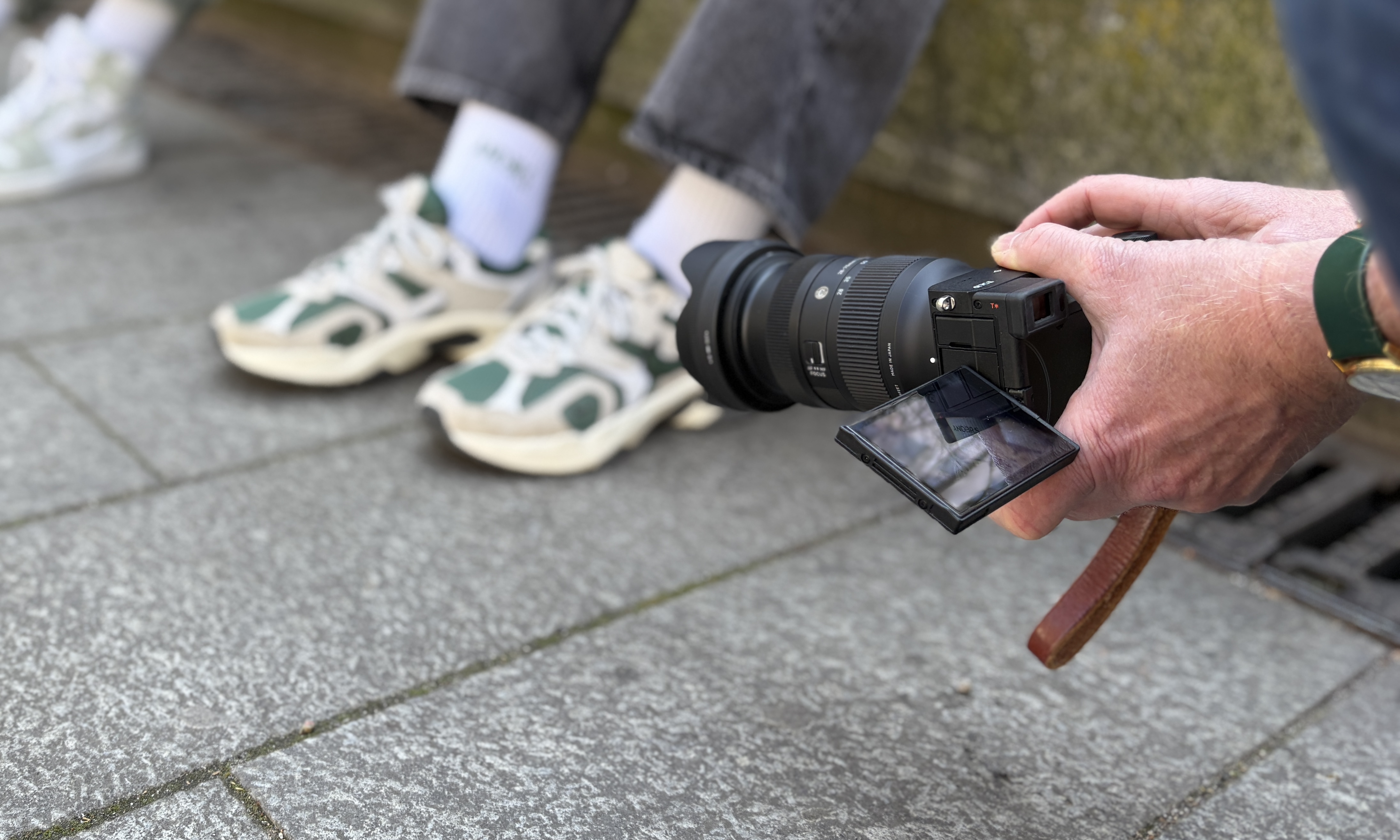 Foto von Turnschuh mit weißer Tennissocke und Aufschrift ANDERS