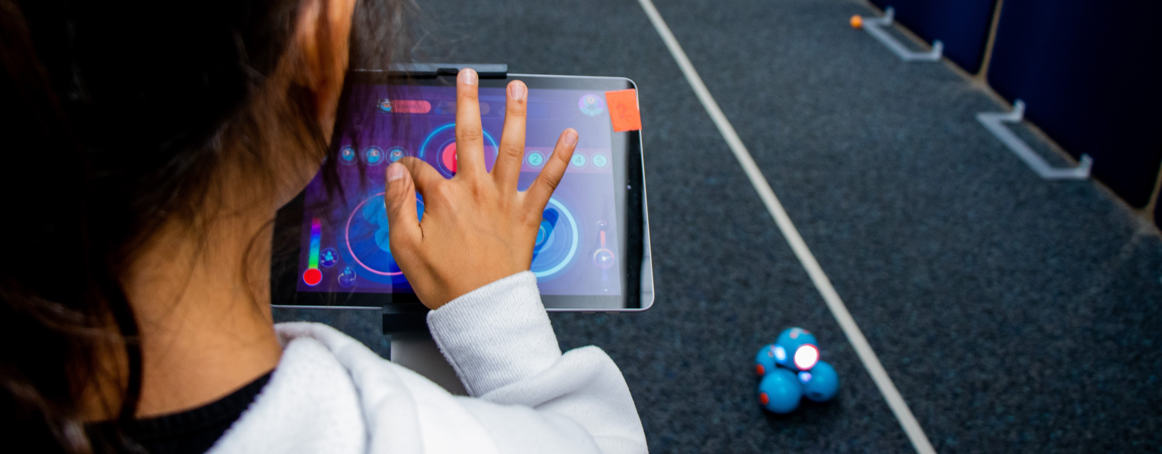 Bild zeigt Schülerin, die per Tablet einen Roboter steuert