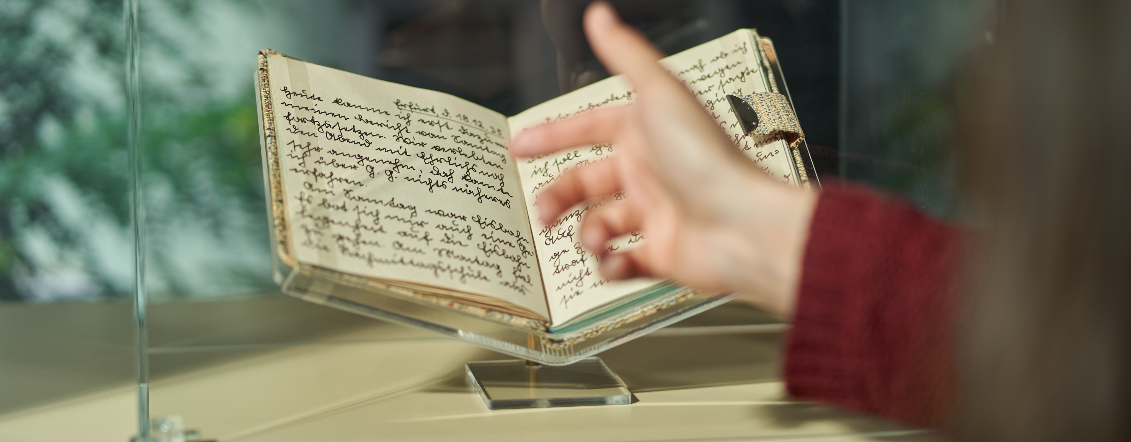 Schüler, der auf ein Buch in einem Museum zeigt.